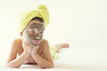 Portrait of a girl with face mask and towel turban on head — Stock Photo