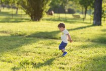Хлопчик бурмоче на траві в парку — стокове фото