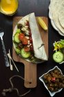 Draufsicht auf Shawarma-Wrap über Kochbrett, Zubereitungsprozess — Stockfoto
