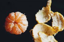 Close-up de fruta de tangerina fresca sem pele, fundo preto — Fotografia de Stock