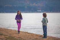 Мальчик и девочка веселятся у озера — стоковое фото