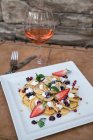 Сладкие блины в белой тарелке с розовым вином — стоковое фото