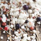 Salt crystals and berries on wooden board — Stock Photo