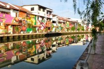 Malasia, Melaka State, Malaca, Graffitied buildings on riverbank - foto de stock