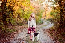 Girl walking fox terrier dog in the woods — Stock Photo