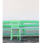 Vista panorámica de la silla verde por la pared blanca - foto de stock