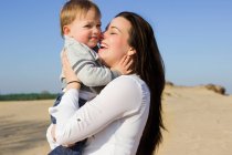 Happy caucasian mother holding cute boy in arms — Stock Photo