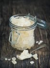 Crystal sugar in glass jar over wooden table — Stock Photo
