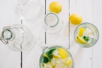 Jarro de vidro com limão fresco, limão, hortelã e cubos de gelo — Fotografia de Stock