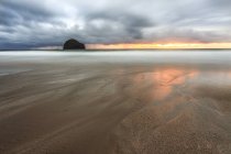 Regno Unito, Inghilterra, Cornovaglia, Trebarwith Strand, Nubi temporalesche sopra la silhouette dell'isola all'orizzonte marino — Foto stock