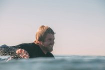 Крупным планом улыбающегося серфера, ловящего волну, Сан-Диего, Калифорния, Америка, США — стоковое фото