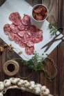 Fette di salame, aglio, pomodori secchi ed erbe aromatiche — Foto stock
