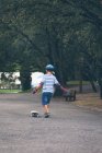 Маленький хлопчик, що носіння шолома скейтбординга в парку — стокове фото