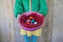 Girl holding bowl of easter eggs — Stock Photo