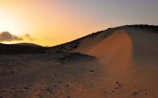 Vista panorámica de la puesta de sol sobre dunas de arena, Corralejo, Fuerteventura, Las Palmas, Islas Canarias, España - foto de stock