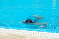 Girl swimming underwater in swimming pool — Stock Photo