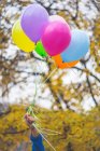 Imagen recortada de hombre mano celebración globos - foto de stock