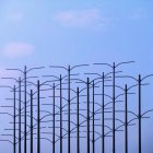Malerischer Blick auf einen Vogel, der an Metallstangen vor klarem blauen Himmel sitzt — Stockfoto