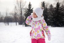 Ragazza che lancia una palla di neve all'aperto in inverno — Foto stock