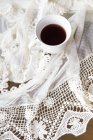 Cup of coffee on a lace tablecloth — Stock Photo