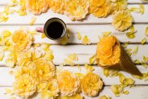 Roses jaunes, cône de crème glacée conceptuel et tasse de café — Photo de stock