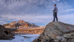 Man standing on rock and looking at mount humphreys, Sierra National Forest, Califórnia, EUA — Fotografia de Stock