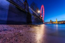 Riverbank en la noche con la ciudad en el fondo, Londres, Reino Unido - foto de stock