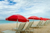 Пляж шезлонги і парасольки поспіль на пляжі — стокове фото