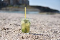 Свежий коктейль мохито на скалах на пляже — стоковое фото