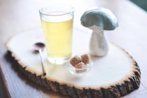 Té de hierbas y azúcar en una tabla de madera con champiñones - foto de stock