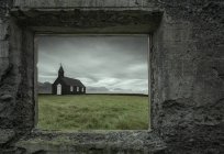 Igreja vista através da janela do edifício abandonado, Budir, Islândia — Fotografia de Stock