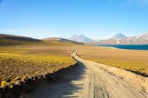 Chile, Altiplano, vista panorâmica ao longo da estrada de terra no deserto com montanhas ao fundo — Fotografia de Stock
