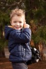Усміхнений хлопчик тримає бінокль в парку — стокове фото