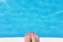 Обрізане зображення жіночих ніг на краю басейну — стокове фото