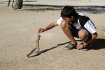 Adolescente ragazzo alimentazione mantello terra scoiattolo — Foto stock