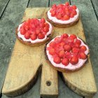 Three strawberry cakes on a chopping board — Stock Photo