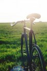 Vista traseira da bicicleta no prado verde fresco — Fotografia de Stock