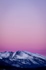 Vista panorámica del majestuoso cielo rosa sobre montañas rocosas - foto de stock