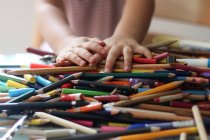 Immagine ravvicinata di mani di bambino con un mucchio di matite colorate — Foto stock