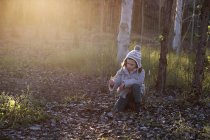 Дівчина тримає осіннє листя в лісі — стокове фото