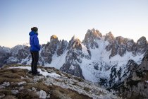 Woman standing in Dolomite Mountains and looking at view, South Tyrol, Itália — Fotografia de Stock