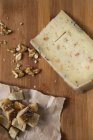 Сверху вид на сыр с гренками и орехами на деревянном фоне — стоковое фото
