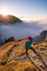 Mulher de pé na montanha olhando para a vista acima das nuvens, Salzburgo, Áustria — Fotografia de Stock