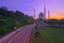 Malaisie, Kuala Lumpur, Route vide avec mosquée bleue sur le fond au crépuscule — Photo de stock