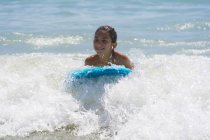 Beautiful girl on surfboard in ocean waves — Stock Photo