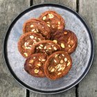 Тарілка мигдалевого та коричневого печива над дерев'яним столом — стокове фото