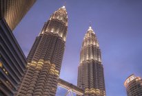 Низкий угол обзора башен-близнецов Петронас ночью, Куала-Лумпур, Малайзия — стоковое фото
