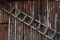 Деревянная лестница висит на стене, полная рама — стоковое фото
