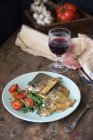 Fisch mit Tomate, grünen Bohnen und einem Glas Rotwein — Stockfoto