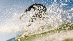 Confident surfer on wave with splashing in ocean — Stock Photo